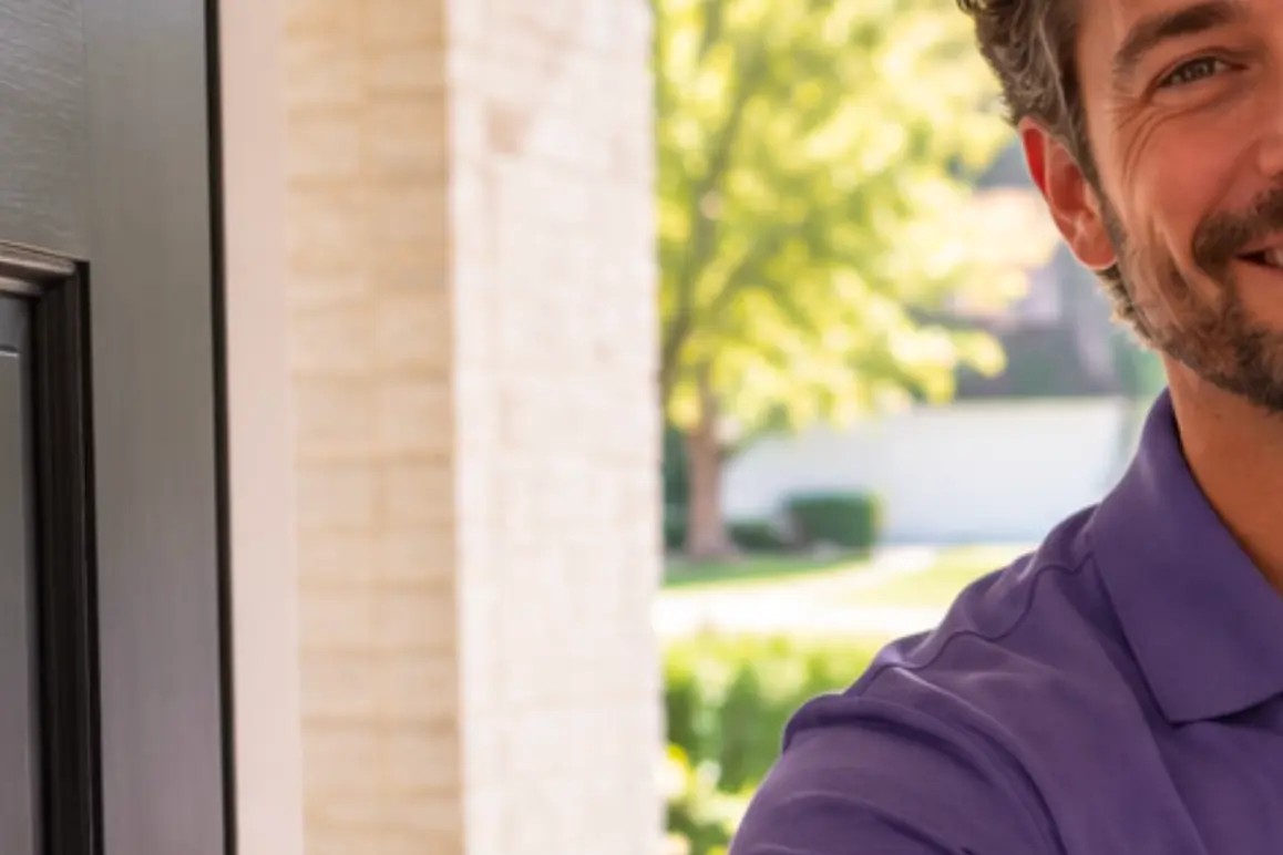 An Aether specialist reaching to greet a homeowner at the front door